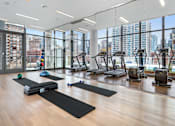 Thumbnail 23 of 25 - A gym with a view of the city outside the windows.