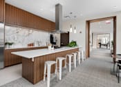 Thumbnail 17 of 25 - A modern kitchen with a long island and bar stools.
