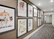 Thumbnail 19 of 25 - A hallway with framed artwork on the wall.
