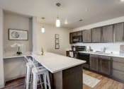 Thumbnail 14 of 23 - a kitchen with a white counter top and wooden cabinets