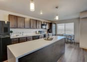 Thumbnail 2 of 23 - a kitchen with a large island and a stainless steel refrigerator