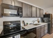 Thumbnail 17 of 23 - a kitchen with stainless steel appliances and black appliances