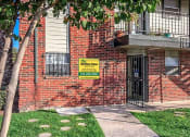 Thumbnail 7 of 8 - a brick building with a yellow sign on the side of it