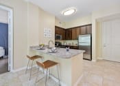 Thumbnail 39 of 44 - a kitchen with a bar and a stainless steel refrigerator