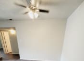 Thumbnail 11 of 36 - an empty living room with wood floors and a ceiling fan