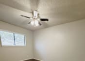 Thumbnail 17 of 36 - an empty living room with wooden floors and a ceiling fan