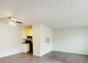 Thumbnail 13 of 36 - an empty living room with a wood floor and a ceiling fan