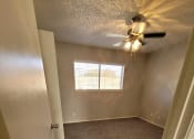 Thumbnail 25 of 36 - an empty room with a ceiling fan and a window