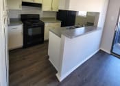 Thumbnail 19 of 36 - an empty kitchen with white cabinets and black appliances