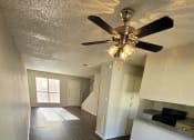 Thumbnail 14 of 36 - a empty living room with a ceiling fan and wood floors