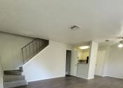 Thumbnail 20 of 36 - an empty living room with wood flooring and a staircase