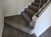 Thumbnail 23 of 36 - a carpeted staircase with white walls and brown carpeted stairs