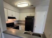 Thumbnail 21 of 36 - a kitchen with a sink and a black refrigerator
