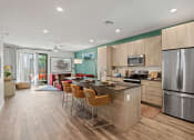 Thumbnail 2 of 30 - a kitchen with a large island and a stainless steel refrigerator