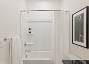 Thumbnail 8 of 30 - a bathroom with a shower and a sink and a shower curtain