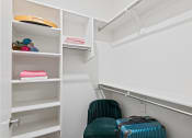 Thumbnail 14 of 30 - a walk in closet with luggage and chairs