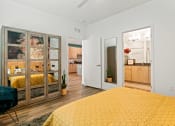 Thumbnail 9 of 30 - a bedroom with a yellow bed and a glass closet