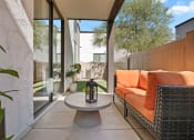 Thumbnail 16 of 30 - a patio with a couch and a table