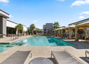 Thumbnail 23 of 30 - a swimming pool with tables and chairs next to a building