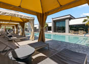 Thumbnail 25 of 30 - a pool with lounge chairs and umbrellas next to a building