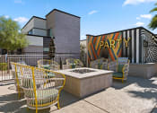 Thumbnail 26 of 30 - a patio with chairs and a fire pit in front of a building