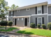 Thumbnail 16 of 36 - a gray house with black shutters and a lawn