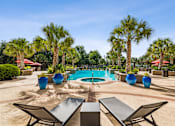 Thumbnail 28 of 42 - A pool surrounded by palm trees and blue vases.