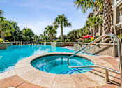 Thumbnail 30 of 42 - A swimming pool surrounded by palm trees and a red umbrella.