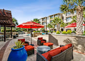 Thumbnail 33 of 42 - A patio with red umbrellas and furniture.