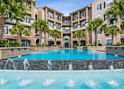 Thumbnail 1 of 42 - A large pool with a fountain in the middle of it.