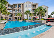 Thumbnail 32 of 42 - A large apartment complex with a pool and fountain.