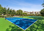Thumbnail 37 of 42 - A blue and green tennis court with a white line down the middle.