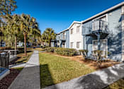Thumbnail 5 of 35 - A sunny day at a residential area with apartment buildings and palm trees.