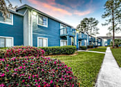 Thumbnail 8 of 35 - A blue building with a white walkway in front.