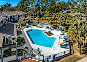 Thumbnail 2 of 35 - A swimming pool surrounded by a fence and chairs.