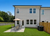 Thumbnail 37 of 37 - A grey house with a patio and a wooden fence.