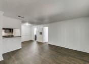 Thumbnail 25 of 25 - an empty living room and kitchen with wood flooring and white walls