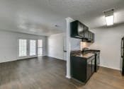 Thumbnail 23 of 25 - the living room and kitchen of an empty apartment with a stove and refrigerator