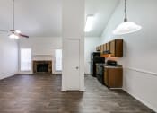 Thumbnail 18 of 25 - an empty living room with a fireplace and a kitchen