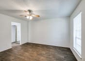 Thumbnail 20 of 25 - an empty living room with a ceiling fan and a window