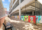 Thumbnail 19 of 25 - a bench in front of a wall with paintings of dogs on it