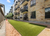 Thumbnail 21 of 25 - an apartment building with a green lawn in front of it