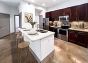 Thumbnail 1 of 25 - a kitchen with a large center island with a sink and two stools