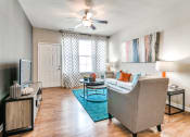Thumbnail 6 of 52 - a living room with a ceiling fan and hardwood flooring