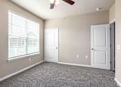 Thumbnail 13 of 52 - an empty living room with a window and a ceiling fan