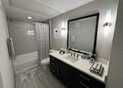 Thumbnail 29 of 33 - a bathroom with a sink and a shower and a mirror