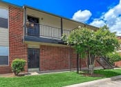 Thumbnail 4 of 8 - the front of a brick building with a tree in the yard