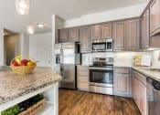 Thumbnail 1 of 42 - a kitchen with stainless steel appliances and granite counter tops