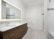 Thumbnail 14 of 25 - A white bathroom with a sink, toilet, and bathtub.