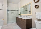 Thumbnail 13 of 25 - A modern bathroom with a glass shower and a white sink.